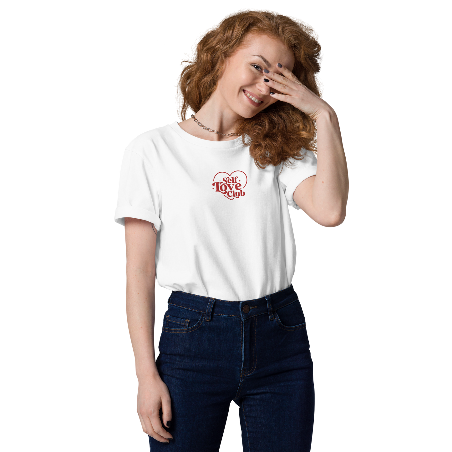 Curly-haired woman in white tee with 'Self Love Club' embroidered on it.