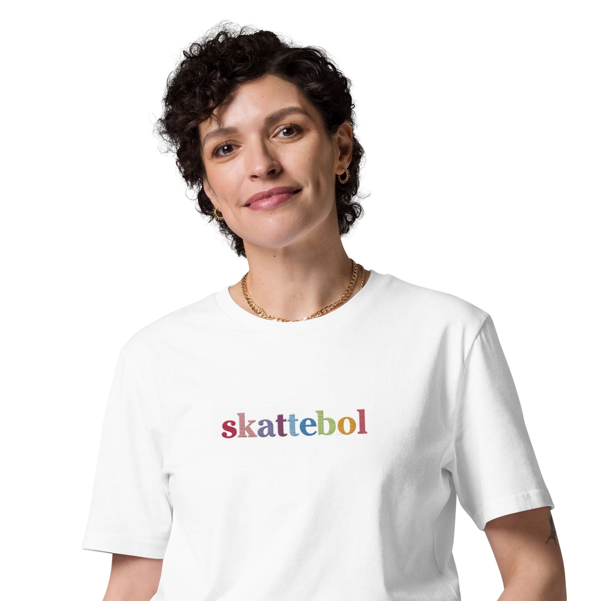 A white t-shirt worn by a lady with a smile, displaying a Skattebol design in rainbow colors, creating a lively and eye-catching look.